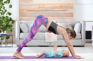 Young sportive woman doing exercise with her son at home