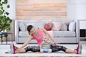 Young sportive woman doing exercise with her son at home