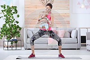 Young sportive woman doing exercise with her son at home