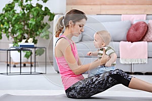 Young sportive woman doing exercise with her son at home.