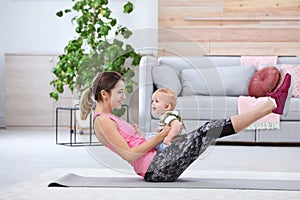 Young sportive woman doing exercise with her son at home