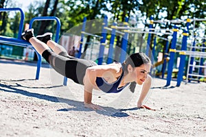 Young sportive woman doing push ups