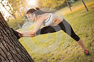 Young sportive woman doing stretching exercises in the park.