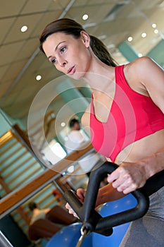 Young sportive woman excercising on a fitness machine