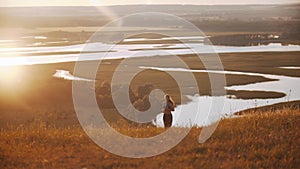 Young sportive woman running on the field on sunset