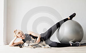 Young sportive woman working out on the fitness ball at home