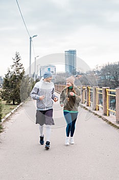 Young sports couple running in the urban environment. Young fitness couple runner running on road in city park near