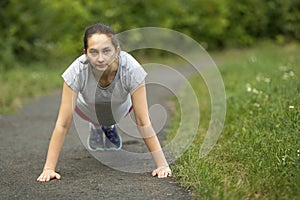 Young sports girl doing warm-up in the Park.