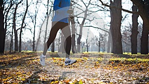 Young Sports Man Running in the Park in Cold Sunny Autumn Morning. Healthy Lifestyle and Sport Concept.