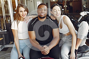 Young sports people sitting in a morning gym