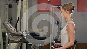Young sports woman doing exercises with dumbbells in the gym. Fitness.