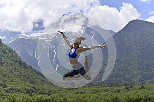 Young sports woman doing yoga on the green grass in the summer.