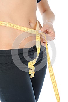 Young sports woman measuring waist.