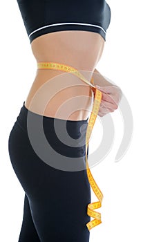 Young sports woman measuring waist.