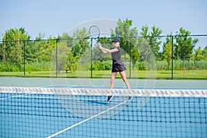 Young sports woman playing tennis on the blue tennis court