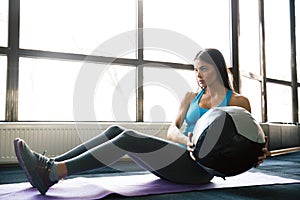 Young sports woman working out with fit ball