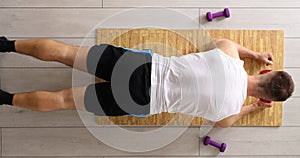 Young sportsman doing exercises on mat top view