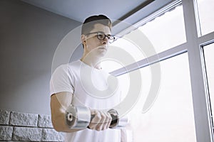 Young sportsman doing workout with dumbbell