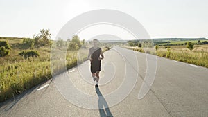 Young sportsman jogging on a race out of city during sunset