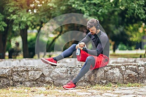 Sportsman listening to music while doing exercising in the park. Fitness, sport, lifestyle concep