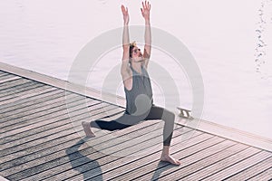 Young sportsman performing articular movements of yoga in an urban area of the city photo