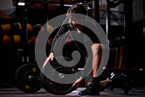 Young sportsman powerlifter preparing for deadlift of barbell during competition