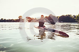 Sportsman in the Red Kayak Paddling on the River.