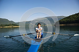 The young sportsman is rowing on the racing kayak