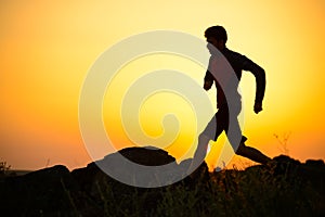 Young Sportsman Running on the Rocky Mountain Trail at Sunset. Active Lifestyle
