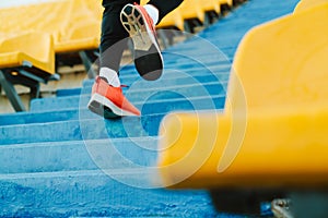 Young sportsman running up the stairs while working out at stadium