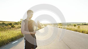 Young sportsman wrapping hand into tape before workout outdoors at nature