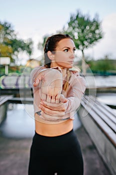 Sportswoman stretching hands and wrists outdoors