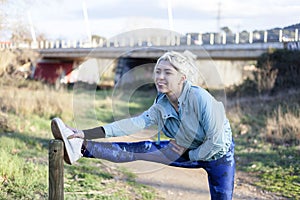 Young sportswoman stretching and preparing to run