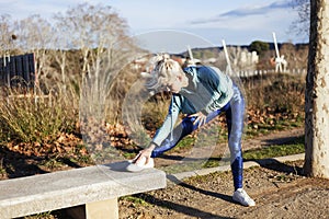 Young sportswoman stretching and preparing to run