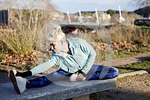 Young sportswoman stretching and preparing to run