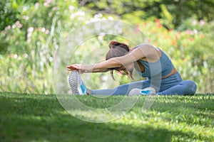 Young sportswoman stretching and preparing to run in park, Fitness woman stretching muscles before sport activity