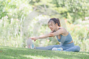 Young sportswoman stretching and preparing to run in park, Fitness woman stretching muscles before sport activity