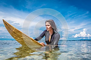 young sportswoman in wetsuit on surfing board in ocean at Nusa dua Beach