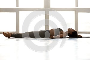 Young sporty attractive woman practicing yoga, doing Dead Body e