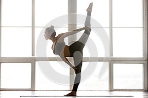Young sporty attractive woman practicing yoga, doing Natarajasan