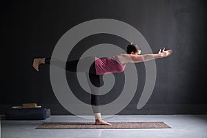 Woman practicing yoga, doing Warrior III exercise, Virabhadrasana 3 pose