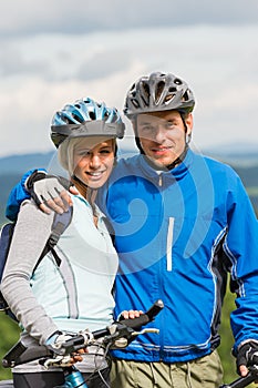 Young sporty couple with mountain bikes in helmet