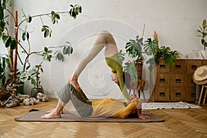 Young sporty couple practicing yoga lesson at light room
