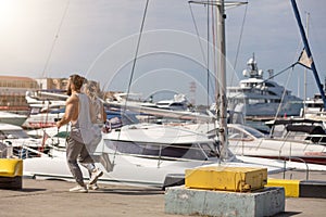 Young sporty couple running over wooden pier at sunset