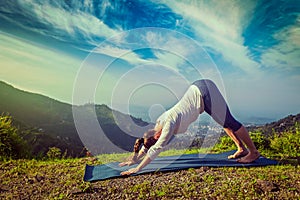 Young sporty fit woman doing yoga oudoors in mountains