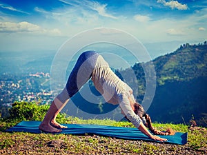 Young sporty fit woman doing yoga oudoors in mountains