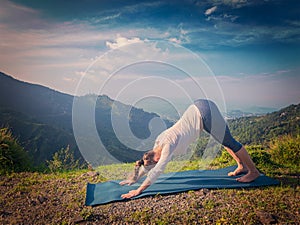 Young sporty fit woman doing yoga oudoors in mountains