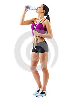 Young sporty girl with skipping rope and water bottle