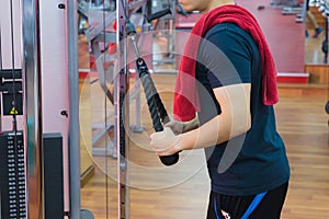 Young sporty man doing rope pulldown in gym. Sport and exercise concept