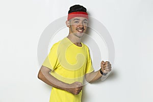 Young sporty man dressed in yellow tshirt running on white background